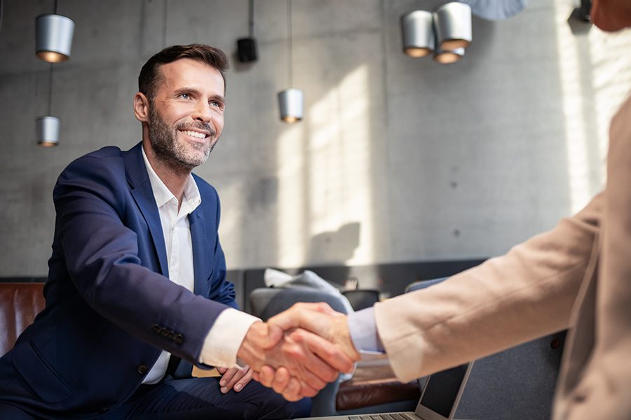 About Our Agency - Business Team Member From Foreshore Insurance Brokers Agency Shaking Hands with Client During a Meeting in a Cafe